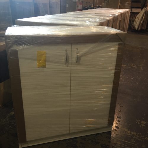 A group of white cabinets sitting in the middle of a warehouse.