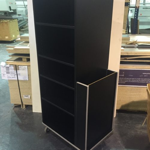 A black shelf with wheels and a small storage unit.