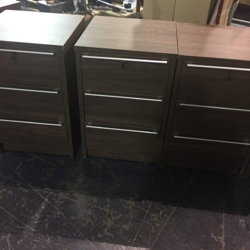 A group of three wooden filing cabinets on top of each other.